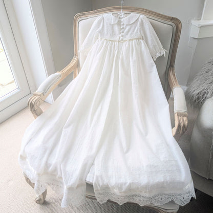 Full-length back view of the Isabella christening gown, demonstrating the traditional open-back skirt design for elegant draping over the arm