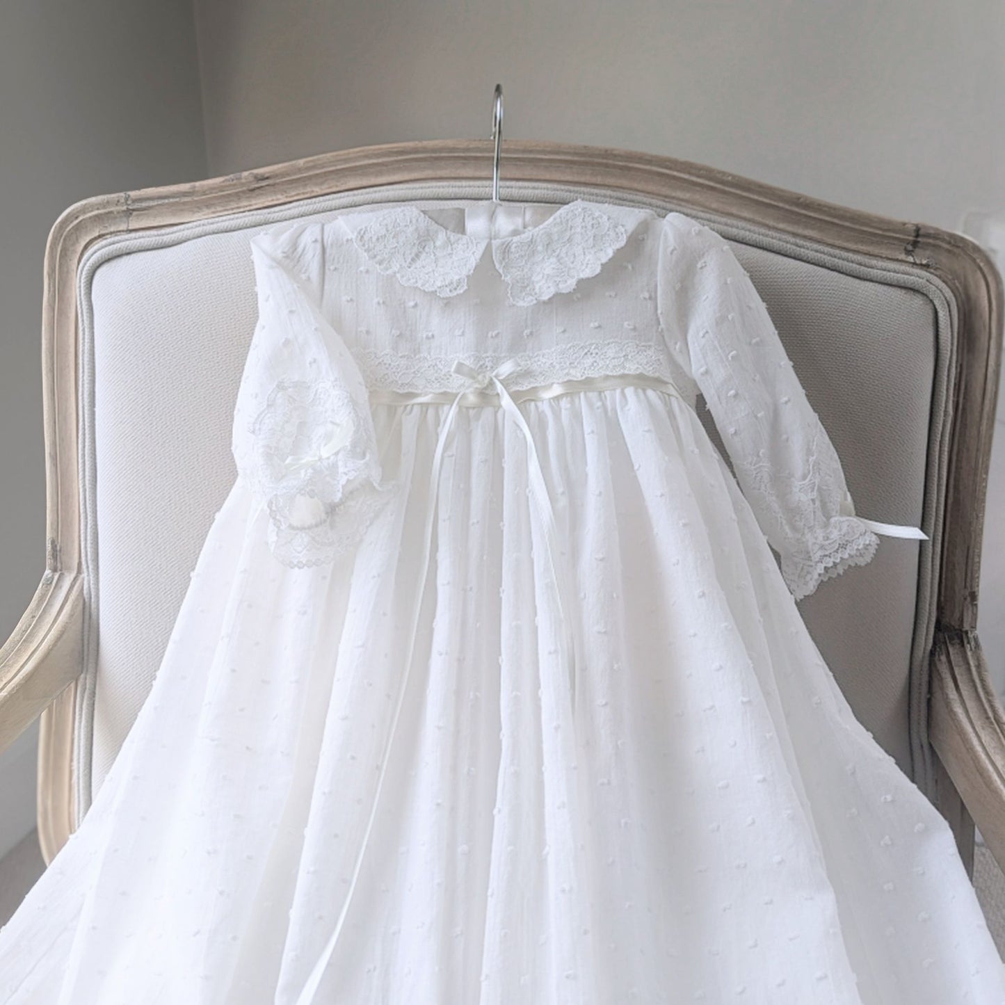 Close-up of the delicate ivory plumeti cotton fabric texture on the Isabella christening gown bodice & sleeves