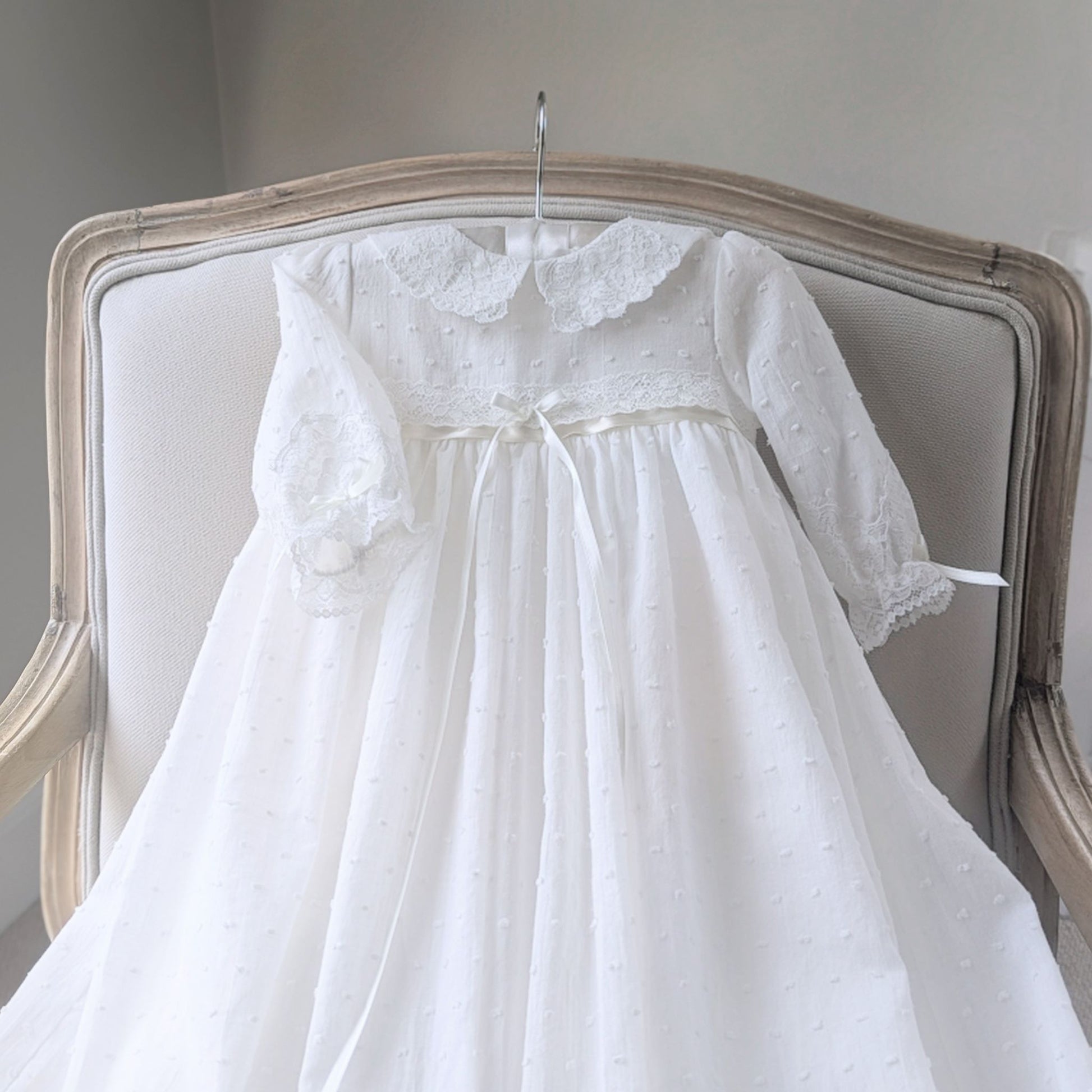 Close-up of the delicate ivory plumeti cotton fabric texture on the Isabella christening gown bodice & sleeves