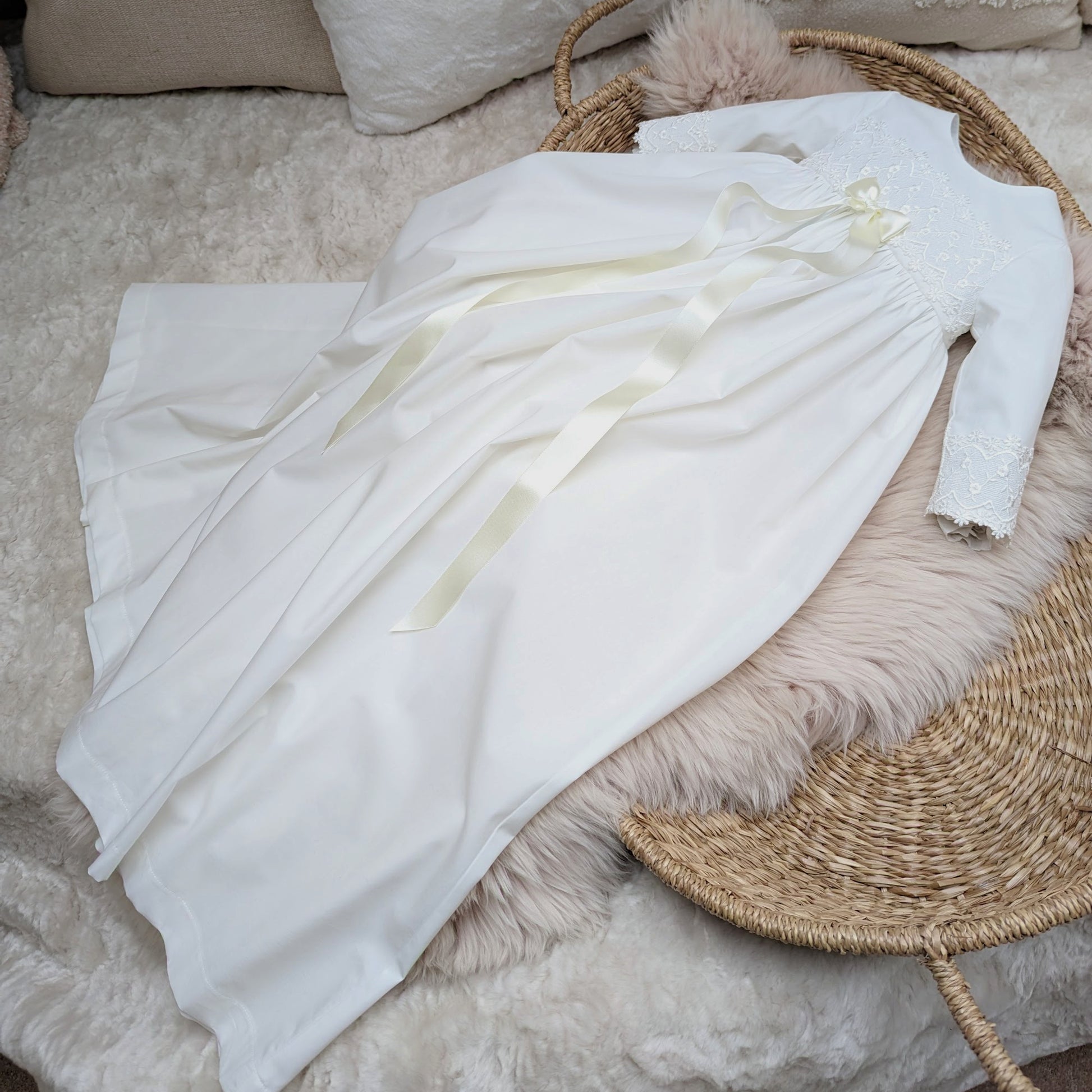 Lana baptism gown shown from the side. Long flowing ribbon on gown