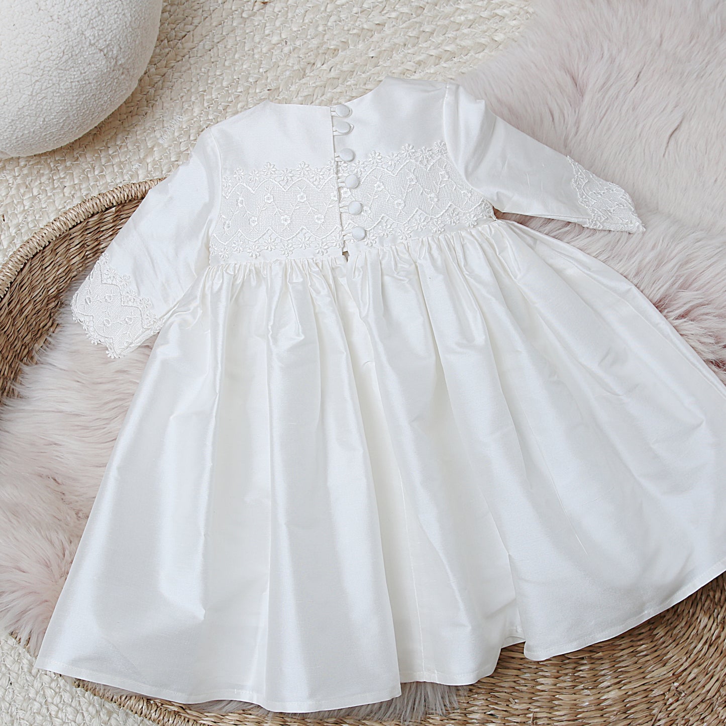 Back detail of the lara long sleeved christening dress showing 6 button and loop fastenings