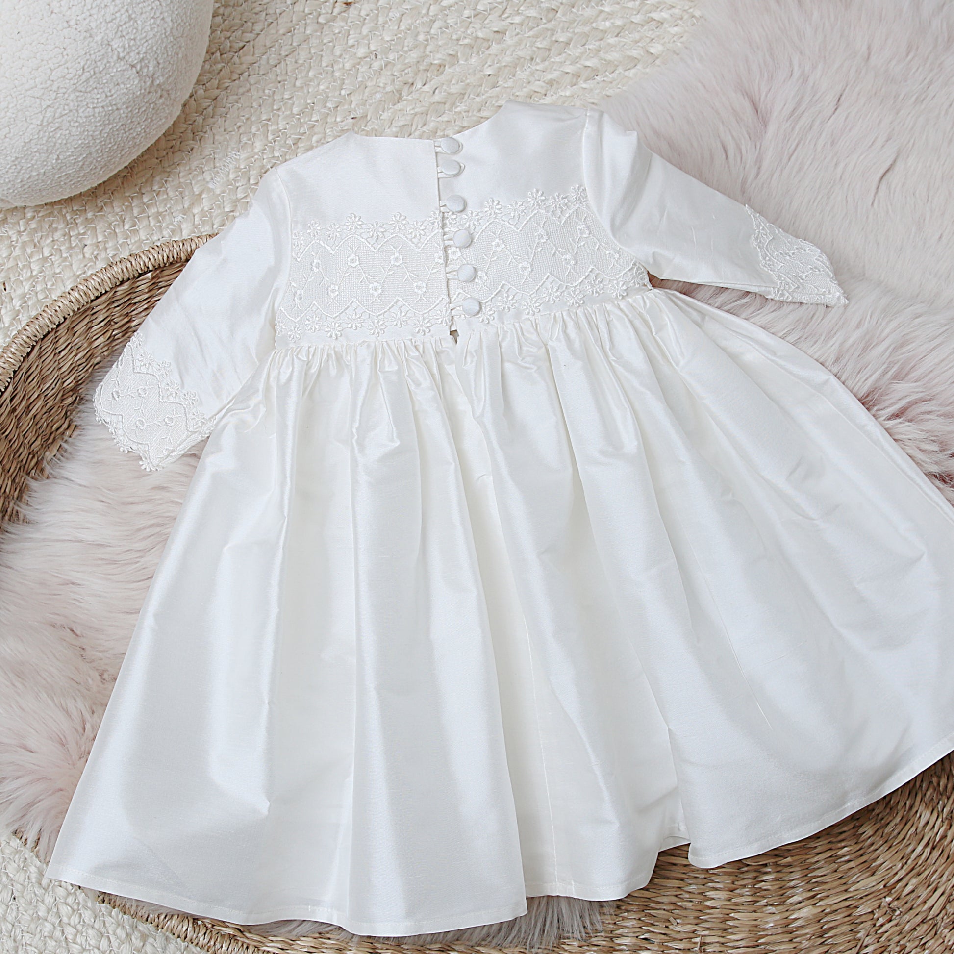 Back detail of the lara long sleeved christening dress showing 6 button and loop fastenings