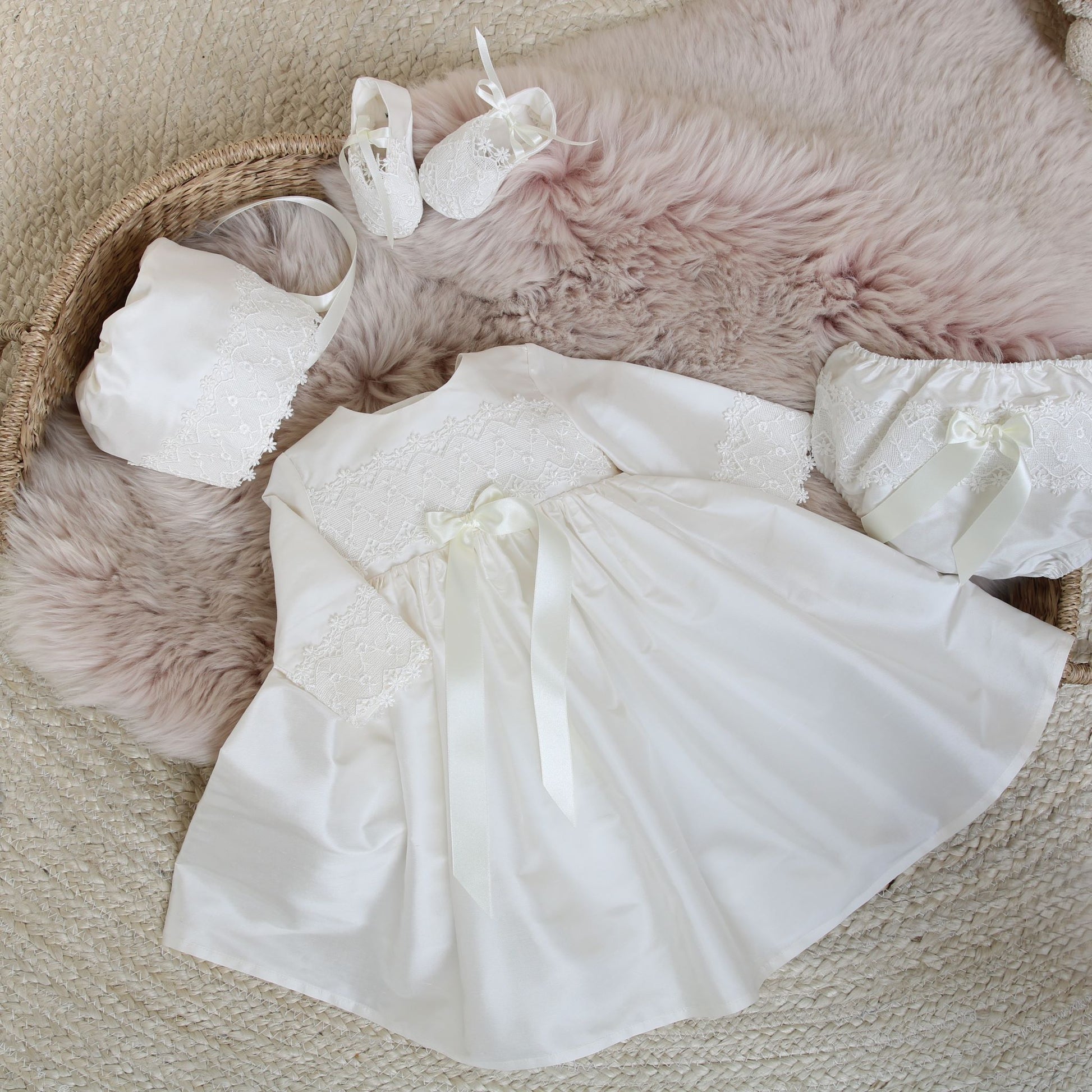 Long sleeved silk and lace handmade baby dress shown with matching bonnet, booties and nappy cover in ivory