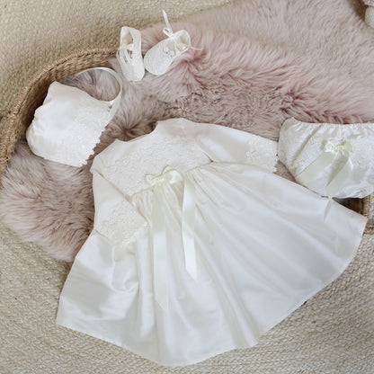 Long sleeved silk and lace handmade baby dress shown with matching bonnet, booties and nappy cover in ivory