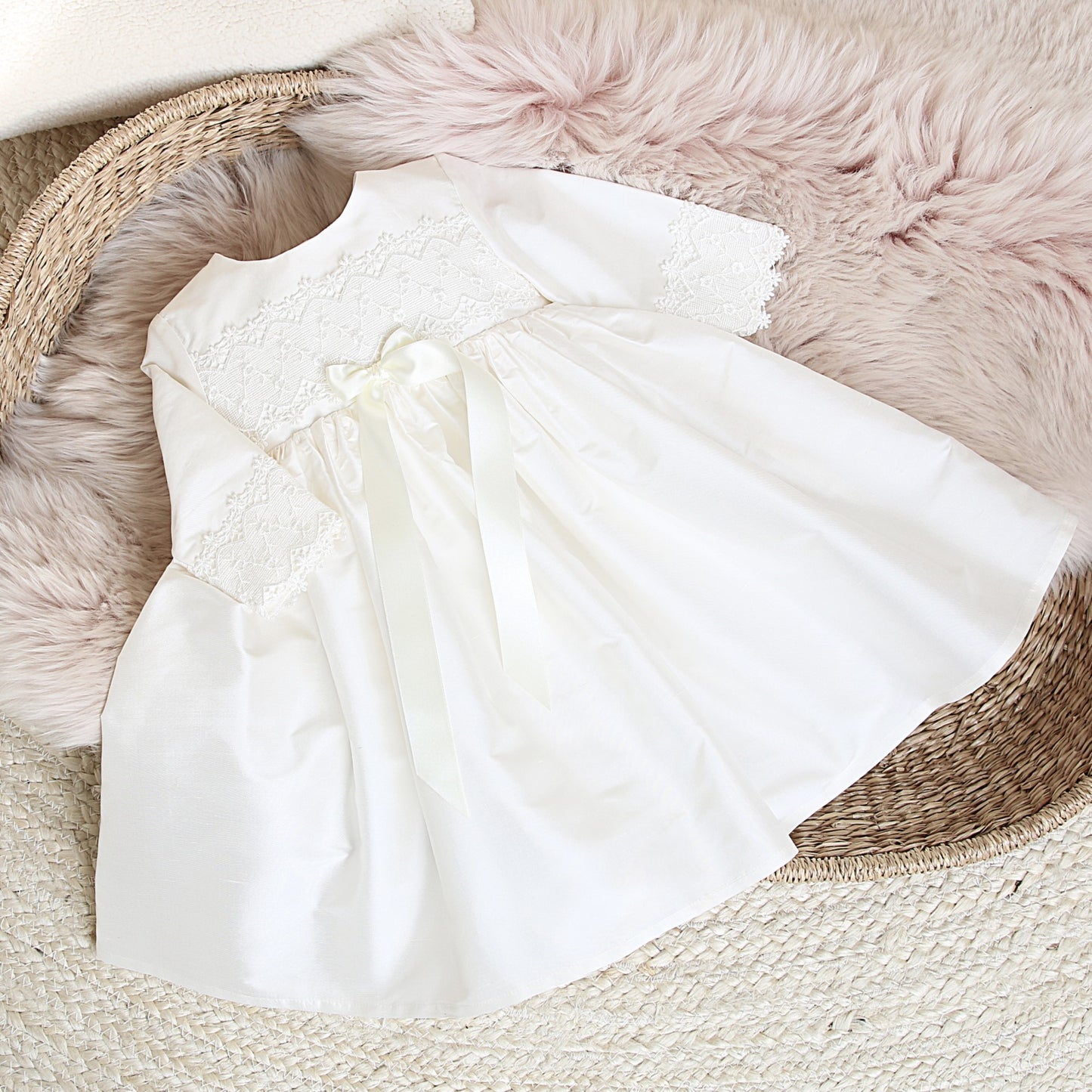 Lara long sleeved baby occasion dress shown in a flatlay style