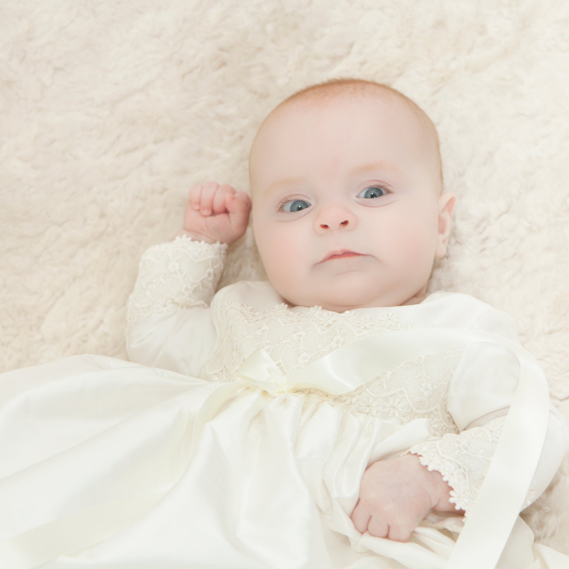 Baby girl wearing the Lara Christening gown. Close up of the bodice and sleeve detail