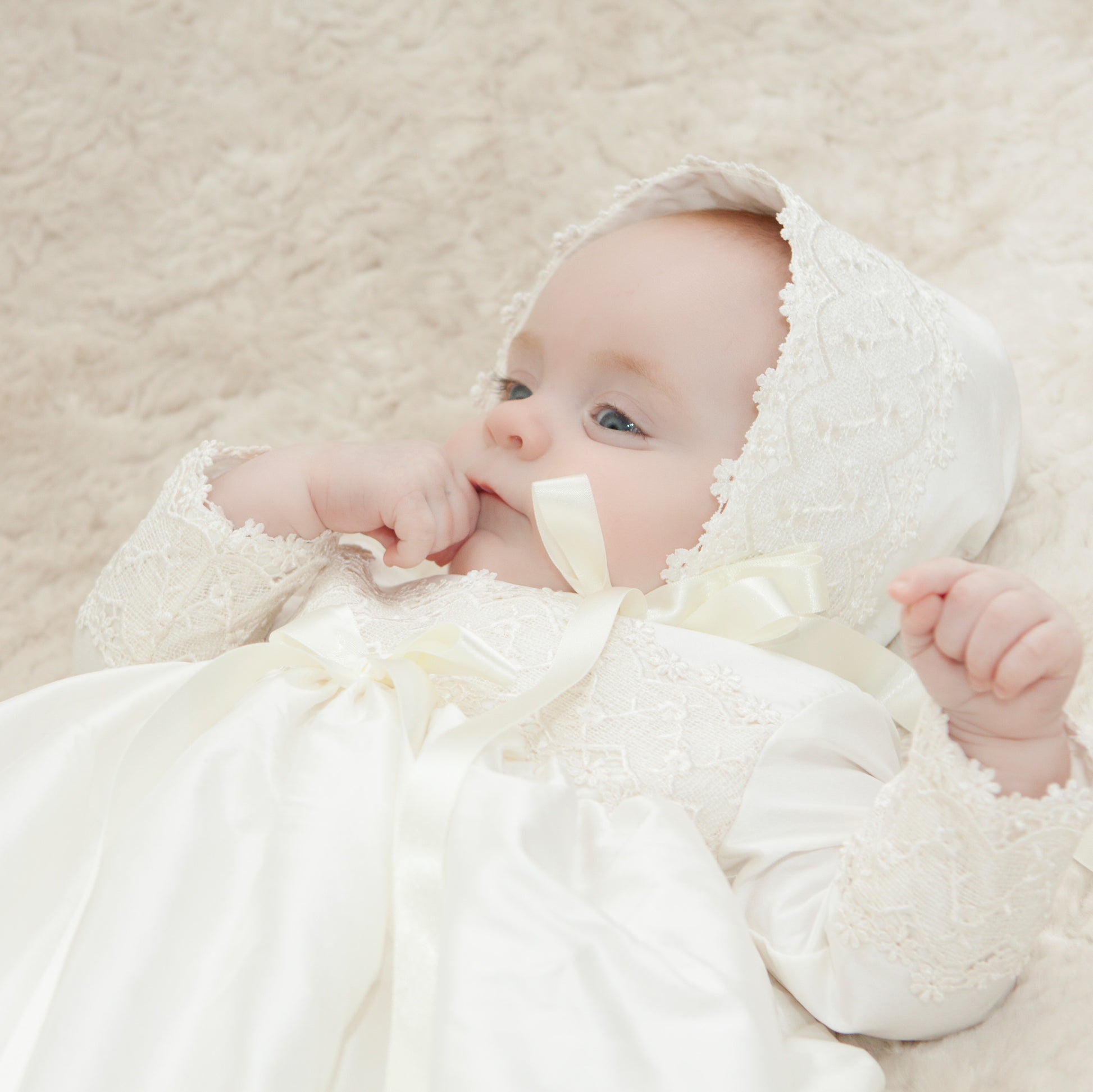 Lucy baptism bonnet shown from the side on a baby girl