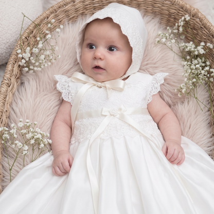 Close up of Baby wearing the traditional ivory silk Rachel Christening Gown with matching Venice lace bonnet