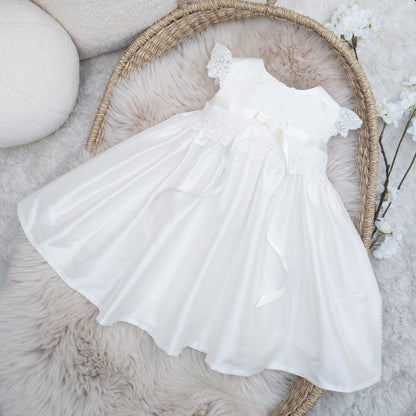 The Rachel silk baptism dress in ivory, showcasing the delicate neckline and bodice details 
