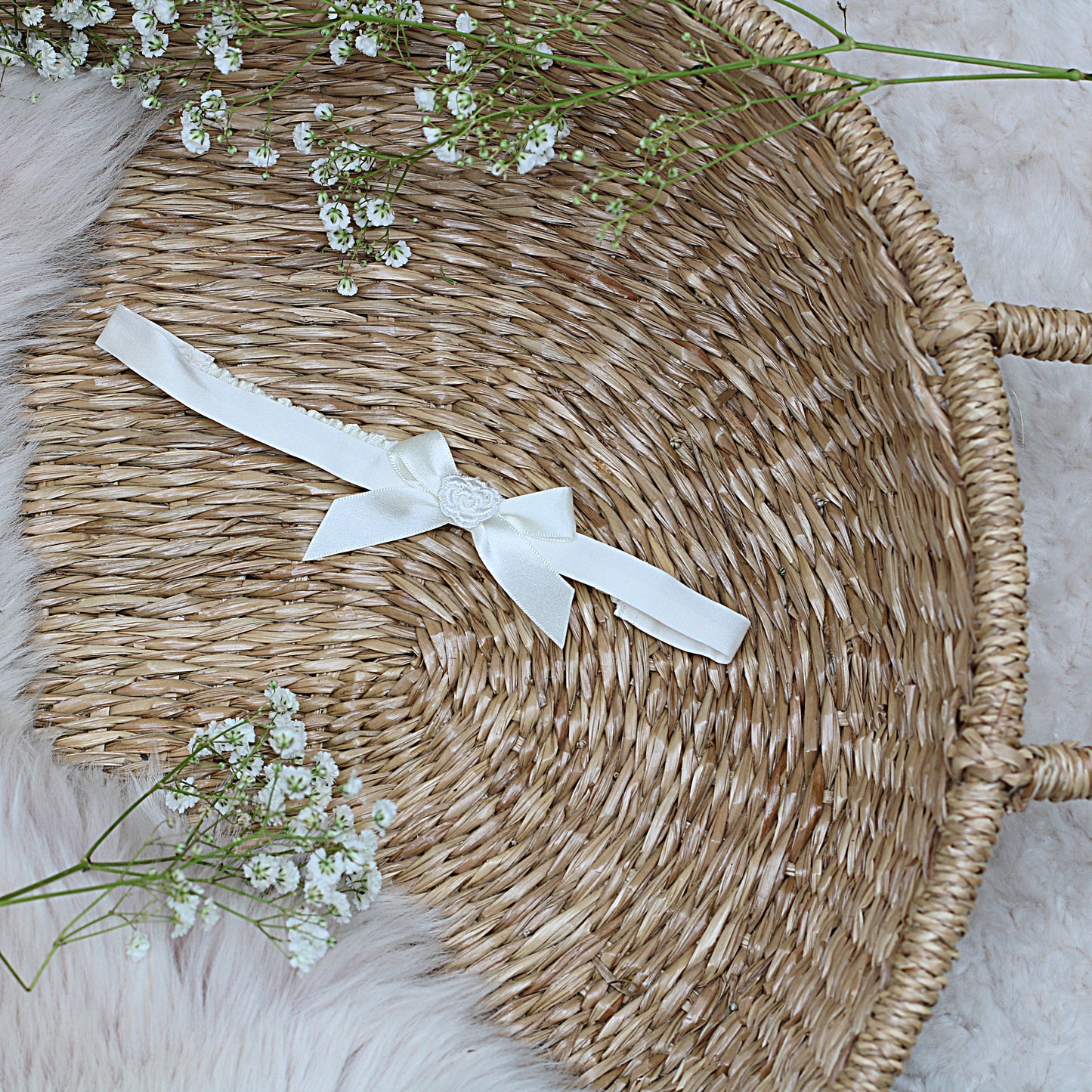 Mila & Moss ivory Rachel silk baby headband featuring a satin ribbon bow and a delicate floral applique centre.