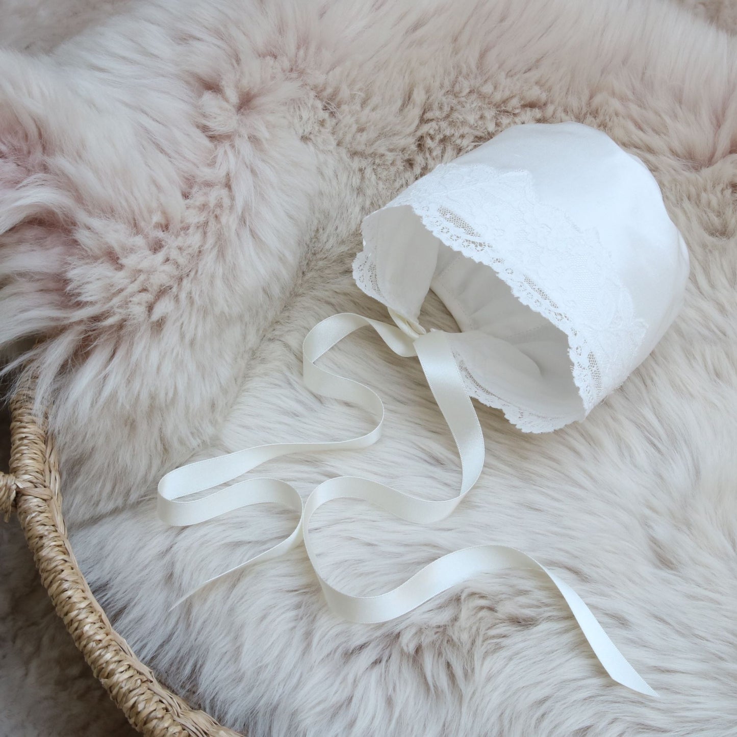 side front view of the Scarlett bonnet on a sheepskin rug