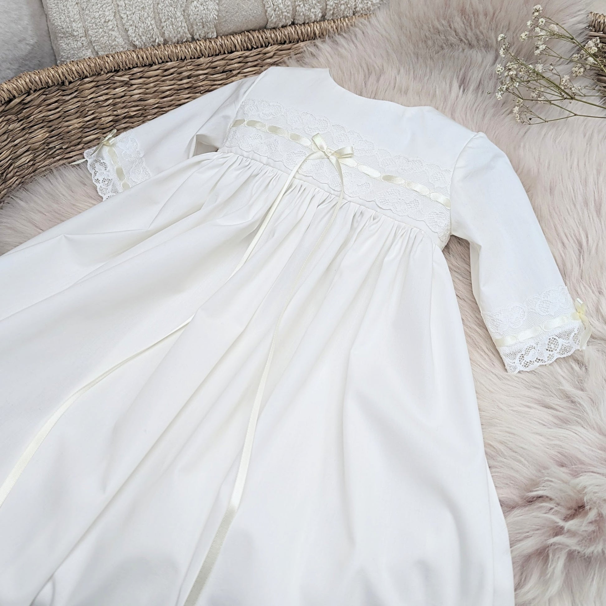 close up detail of the ivory Vivienne cotton christening gown showing lace and ribbon detail