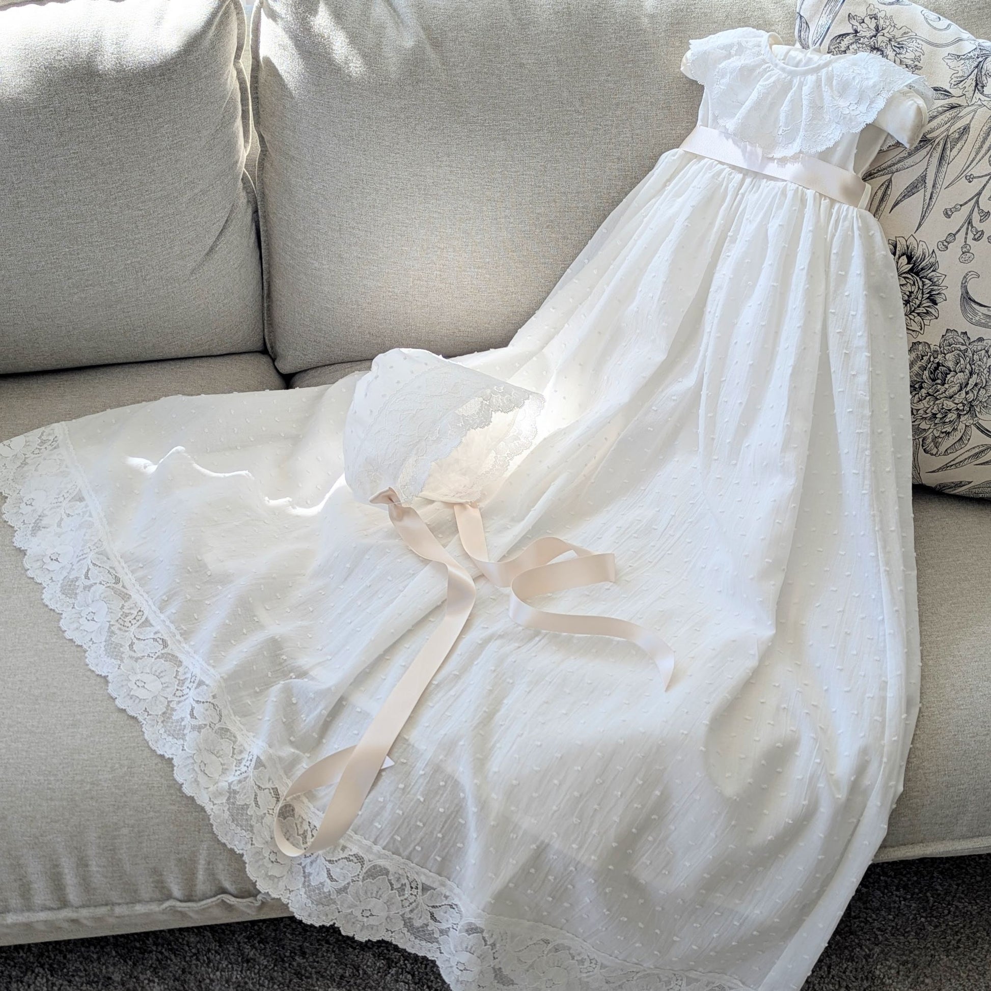 The traditional ivory Eliana baptism gown with its matching fully lined cotton bonnet and satin ties.