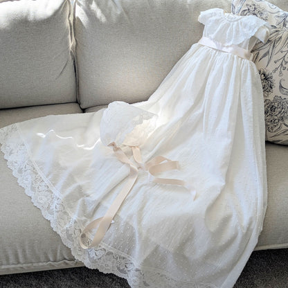 The traditional ivory Eliana baptism gown with its matching fully lined cotton bonnet and satin ties.
