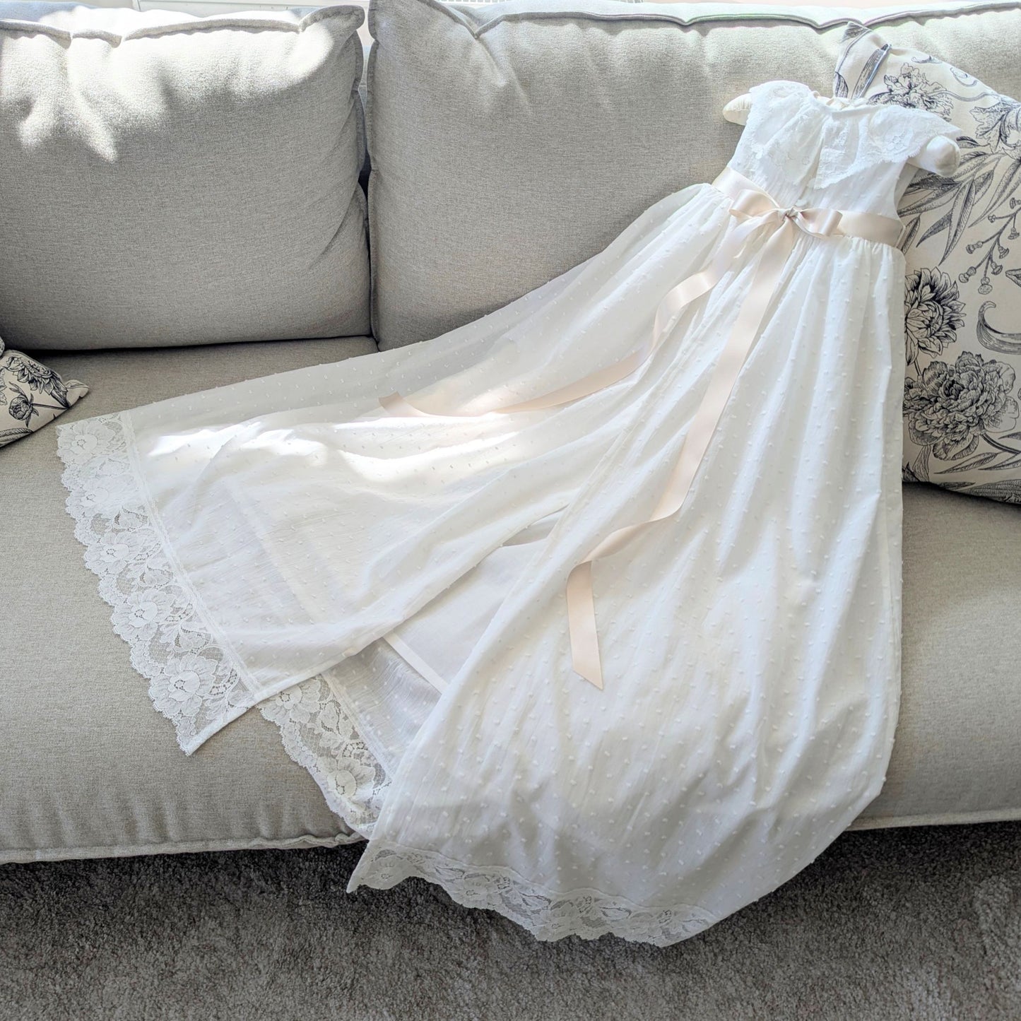 Back view of the Eliana christening gown highlighting the traditional open back skirt, fully lined in cotton.
