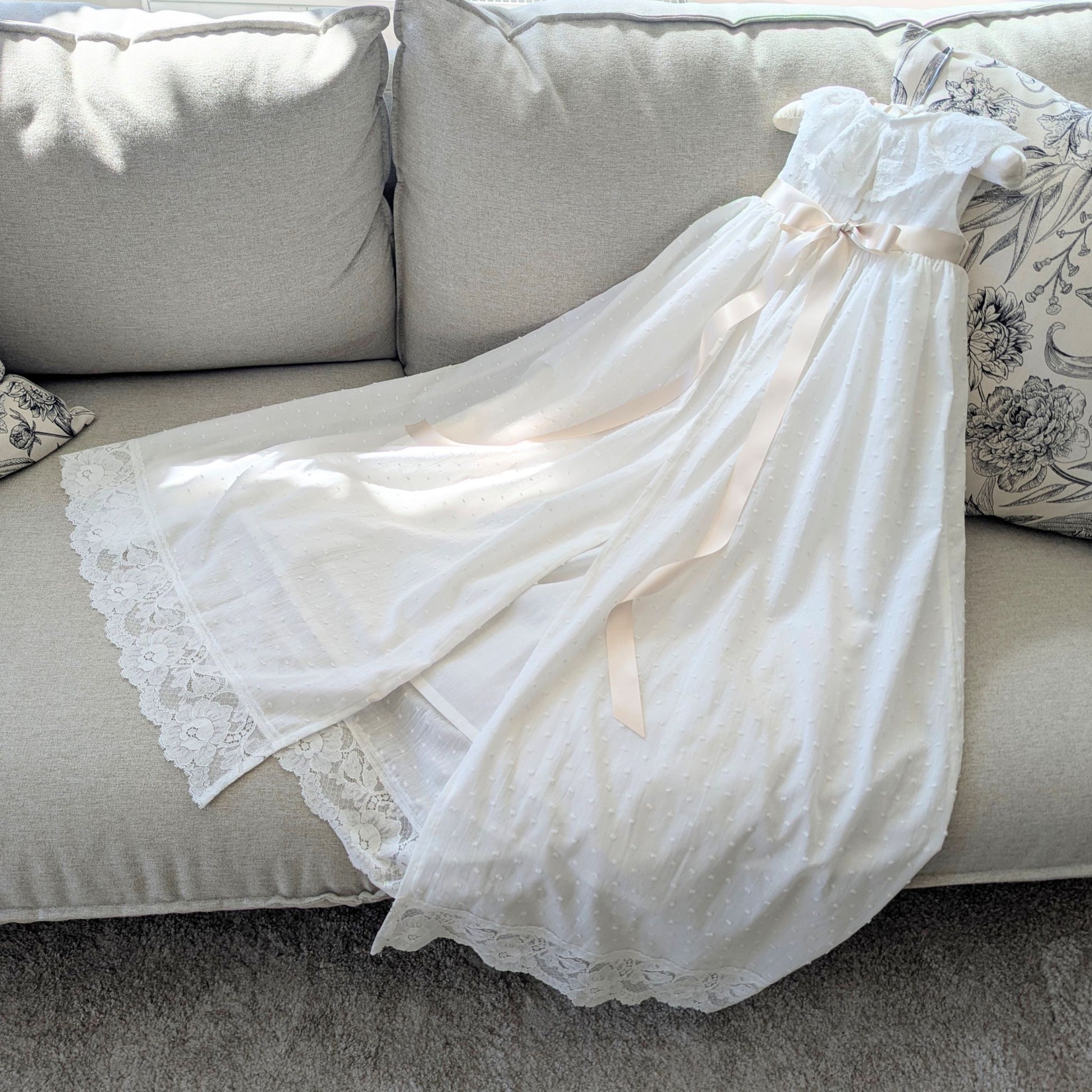 Back view of the Eliana christening gown highlighting the traditional open back skirt, fully lined in cotton.
