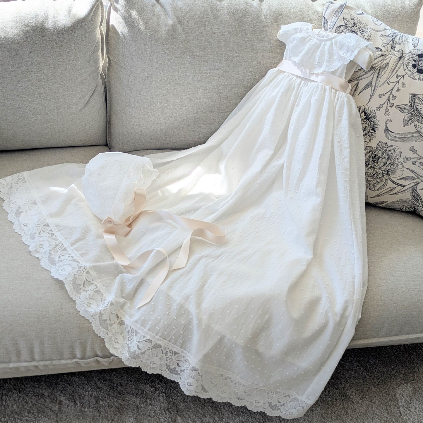 The traditional ivory Eliana baptism gown with its matching fully lined cotton bonnet and satin ties.