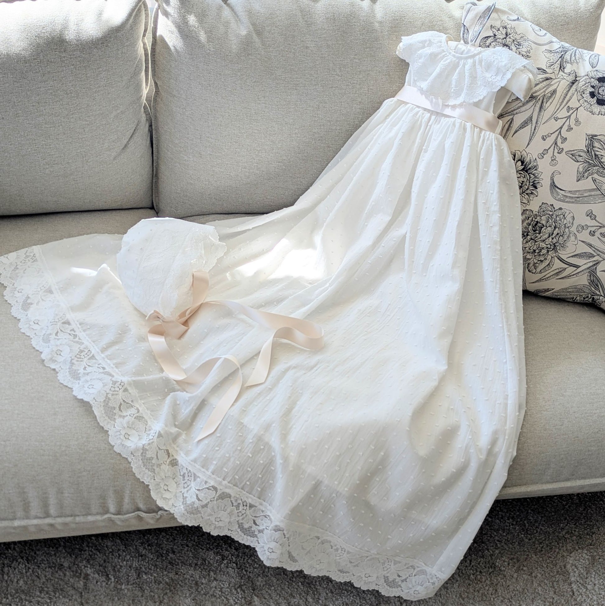The traditional ivory Eliana baptism gown with its matching fully lined cotton bonnet and satin ties.