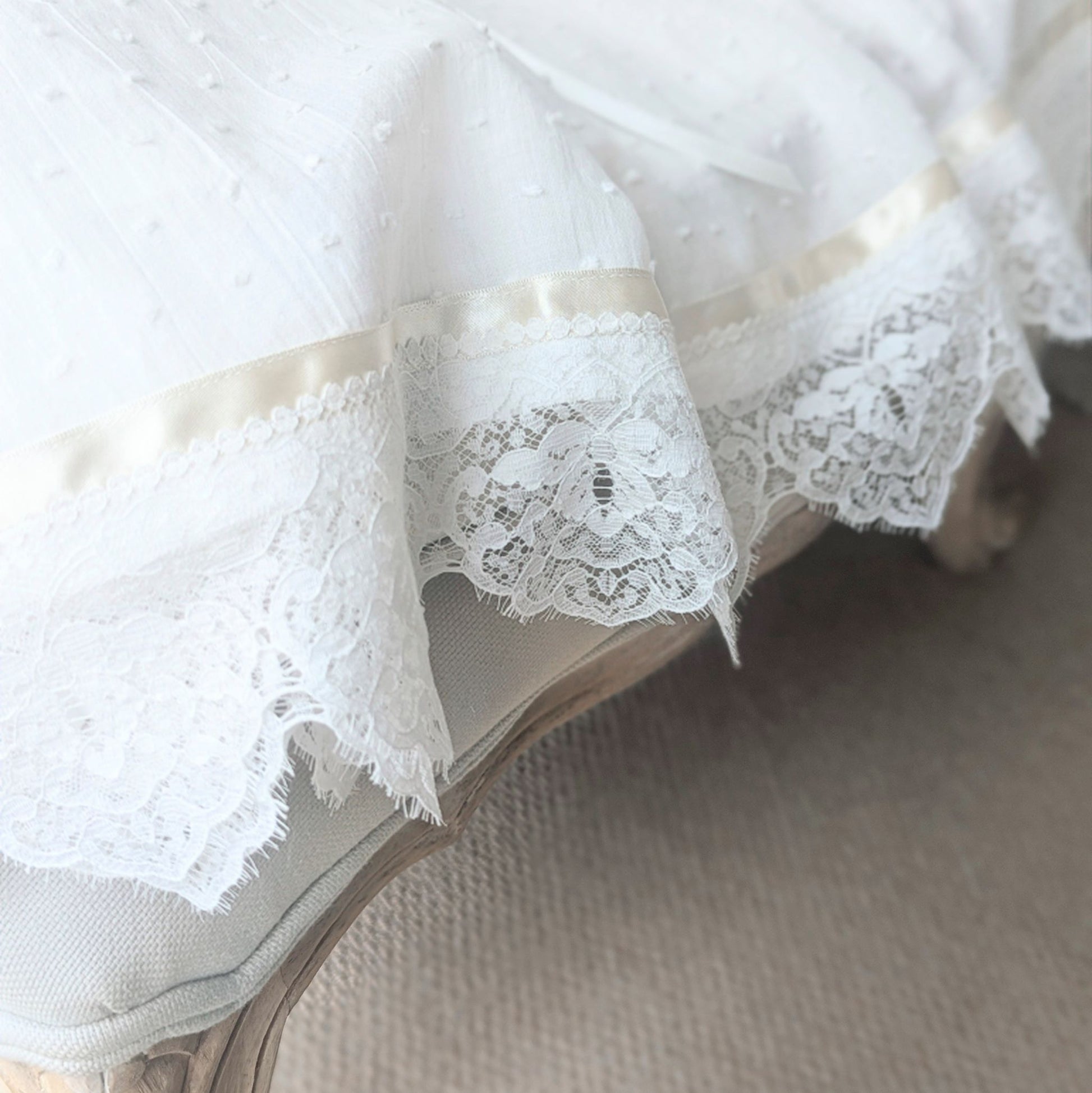 Macro view of the high-quality French lace hem details on the Isabella heirloom gown.