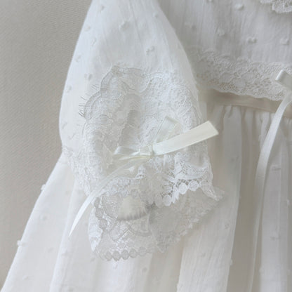 Macro view of the lace and bow sleeve details on the Isabella Cotton Baptism heirloom gown.
