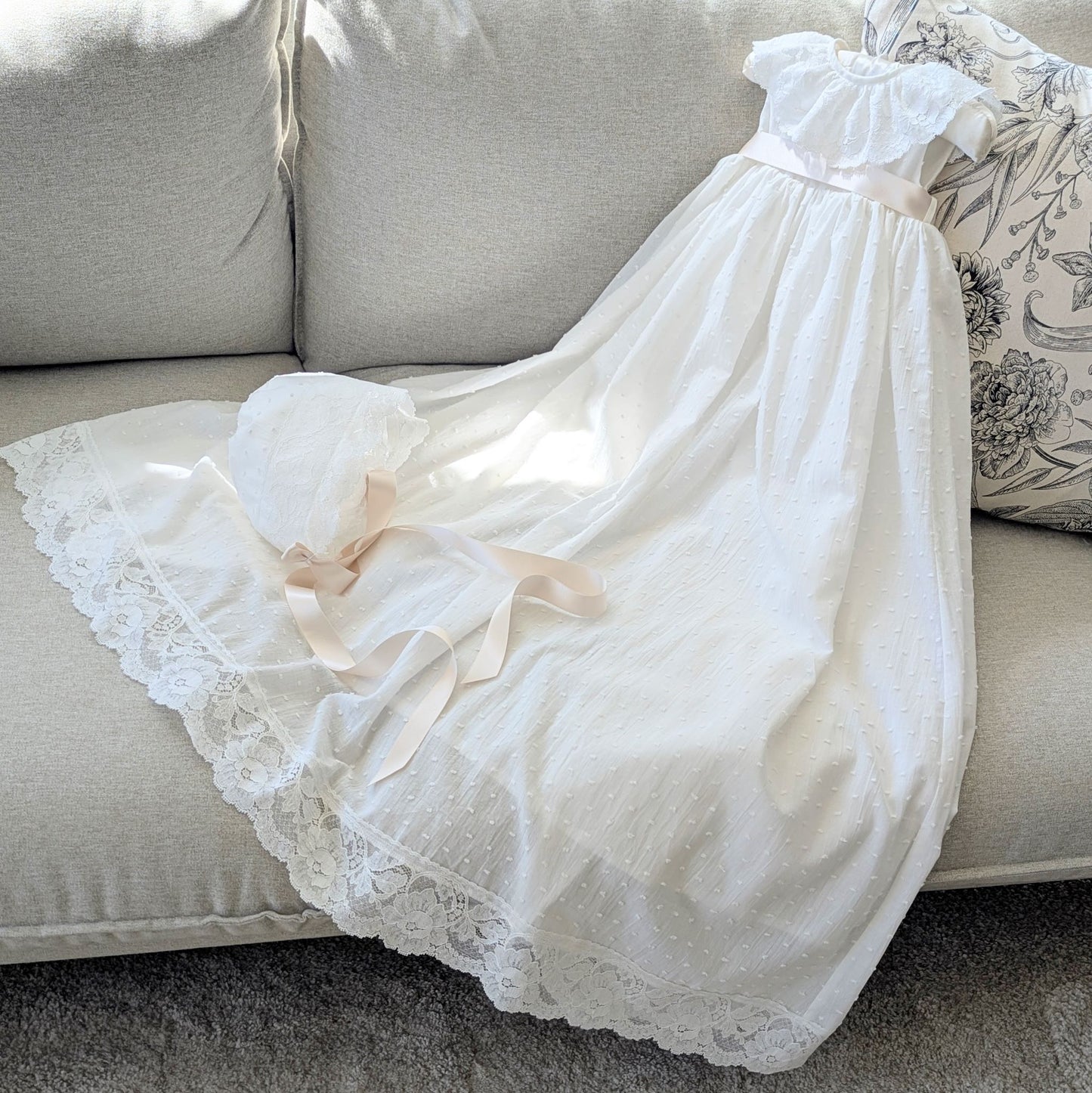 The frill collar ivory Eliana baptism gown with its matching fully lined cotton bonnet and satin ties.