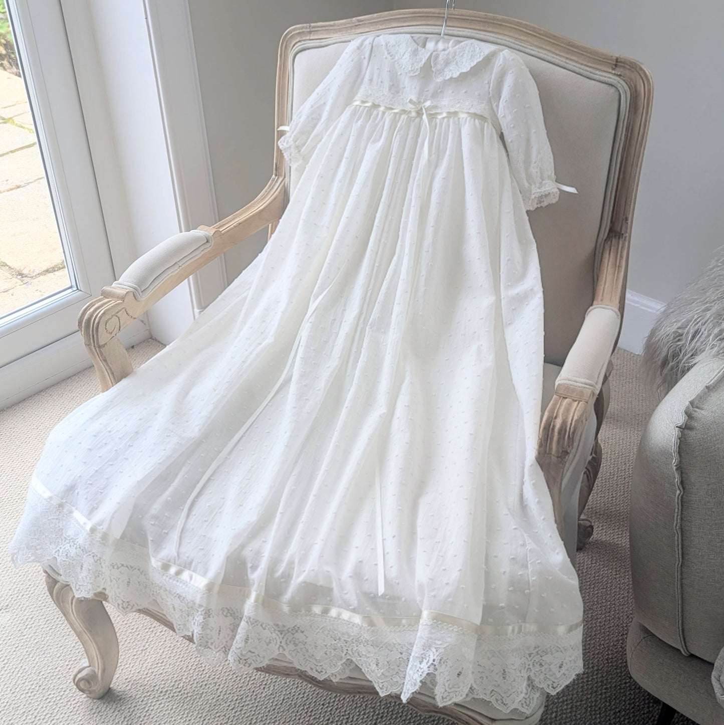 Traditional long ivory christening gown with long sleeves and a wide French lace hemline