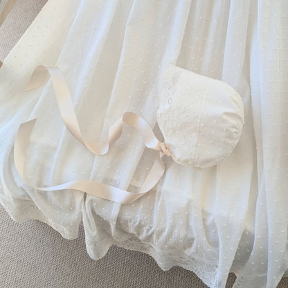 The draped hemline and bonnet of the long Eliana christening gown, showcasing the intricate wide French lace.